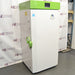 Left angle product view of a Stirling Ultracold SU780XLE ultra-low freezer, showing the white side panel, green top housing, green door handle, and branding on the front door