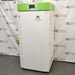 Right angle product view of a Stirling Ultracold SU780XLE ultra-low freezer, showing the white side panel with hinge hardware, green top housing, and branding on the front door
