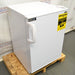 Front angled perspective view of a Summit undercounter all-freezer on a wooden pallet, showcasing its white cabinet body, solid front door with an ergonomic handle, and a yellow EnergyGuide label
