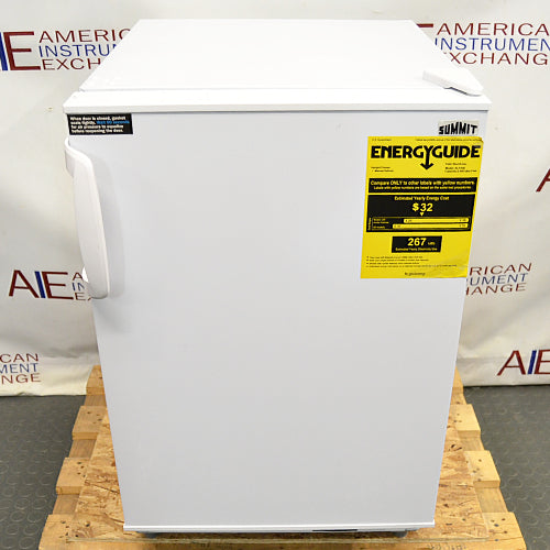 Front eye-level view of a Summit undercounter all-freezer resting on a wooden pallet, featuring a white exterior housing, a solid front door with an exterior handle, and a prominent yellow EnergyGuide label