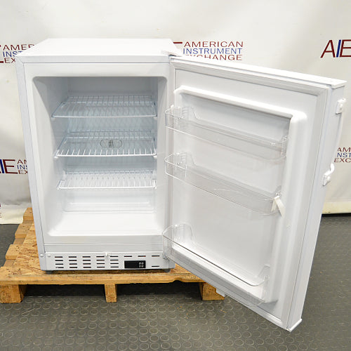Front view of a Summit undercounter all-freezer with its door open on a wooden pallet, revealing interior wire shelving, door storage bins, and a bottom front control module