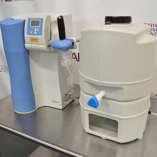 Right angle view of a Thermo GenPure Pro UV/UF water purification system, showing the main purification unit with a blue accent panel, digital display, dispensing valve, and a side storage tank on a stainless steel bench   
