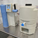 Right angle view of a Thermo GenPure Pro UV/UF water purification system, showing the main purification unit with a blue accent panel, digital display, dispensing valve, and a side storage tank on a stainless steel bench   