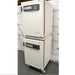 Right angled perspective view of a stacked pair of Thermo Heracell VIOS 160i CO₂ incubators on a rolling stand with closed doors showing touch display panels