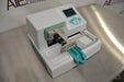 Right three-quarter angle product view of a Thermo Multidrop Combi reagent dispenser, showcasing its white housing, digital display interface, and dispensing cassette setup