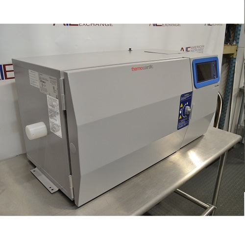 Left angled perspective view of a Thermo Scientific CryoMed controlled rate freezer resting on a stainless steel surface displaying the side panel, front door, and digital touchscreen interface