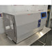 Left angled perspective view of a Thermo Scientific CryoMed controlled rate freezer resting on a stainless steel surface displaying the side panel, front door, and digital touchscreen interface