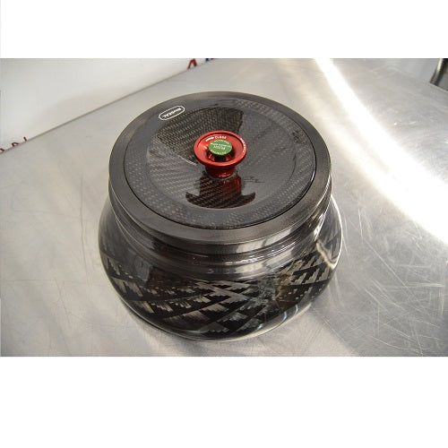 Angled perspective view of a Thermo Scientific Fiberlite F13-14x50cy carbon fiber centrifuge rotor resting on a stainless steel surface featuring a red and green central locking lid mechanism