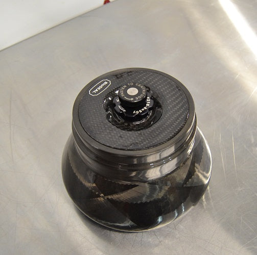 Top-down view of a Thermo Scientific Fiberlite F21-8x50cy carbon fiber centrifuge rotor resting on a stainless steel surface featuring a central locking lid mechanism