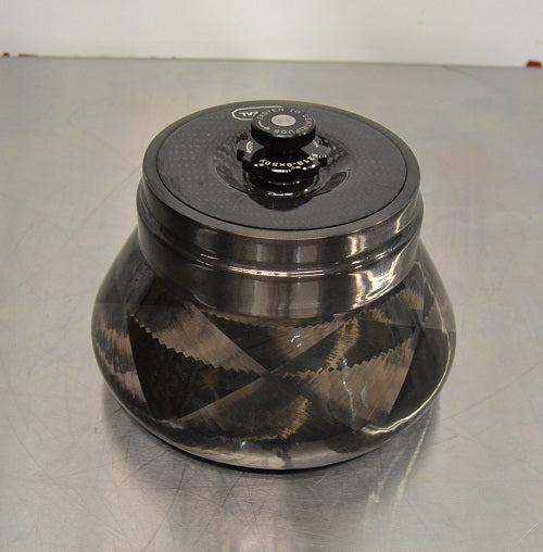 Angled perspective view of a Thermo Scientific Fiberlite F21S-8x50Y carbon fiber centrifuge rotor resting on a stainless steel surface showcasing its tapered body and central lid