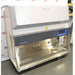 Three-quarter high-angle perspective view of a Thermo Scientific Herasafe 2030i Class II Type A2 biosafety cabinet showing its stainless steel interior chamber, side glass panel, and blue-accented touchscreen display
