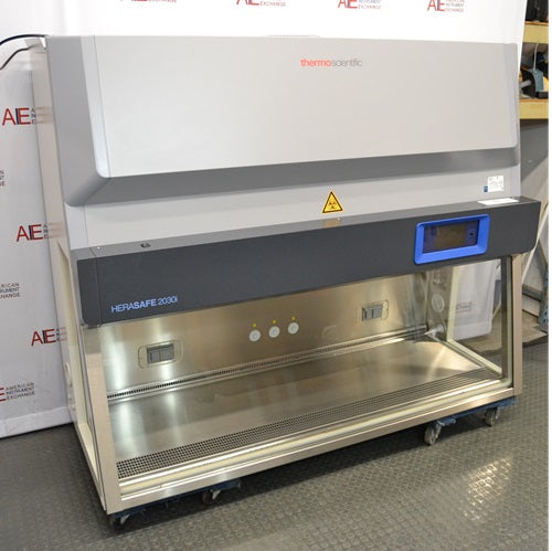 High three-quarter angle view of a Thermo Scientific Herasafe 2030i Class II Type A2 biosafety cabinet showing the stainless steel interior workspace, glass side window, and top cabinet panel