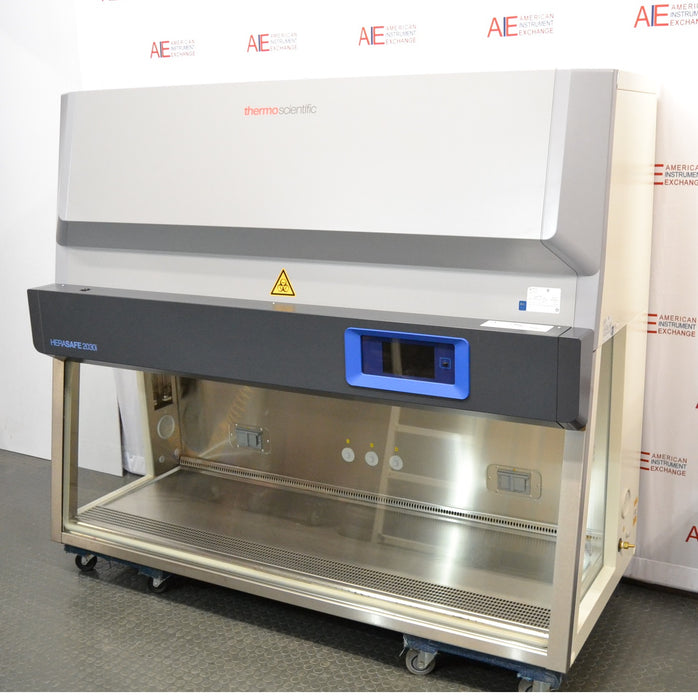 Low three-quarter perspective view of a Thermo Scientific Herasafe 2030i Class II Type A2 biosafety cabinet mounted on a wheeled base showing the open interior work surface and control panel