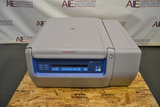 Front eye-level view of a Thermo Scientific Megafuge ST4R Plus MD refrigerated centrifuge with its lid completely closed, featuring the digital control panel, branded housing, and gray benchtop cabinet resting on a wooden pallet base
