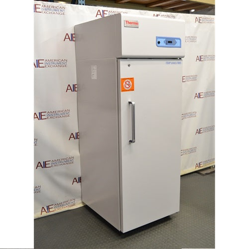 Left angled perspective view of Thermo Scientific TSFMS2305A flammable material storage refrigerator showing solid door, side casing, safety label, vertical handle, and top digital control console