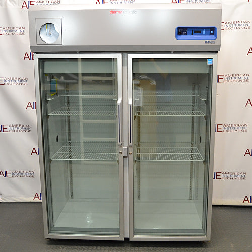 Front product view of a Thermo Scientific TSX5005CA high-performance laboratory refrigerator, featuring dual glass doors, wire shelving inside, a top-mounted control panel, and an integrated chart recorder