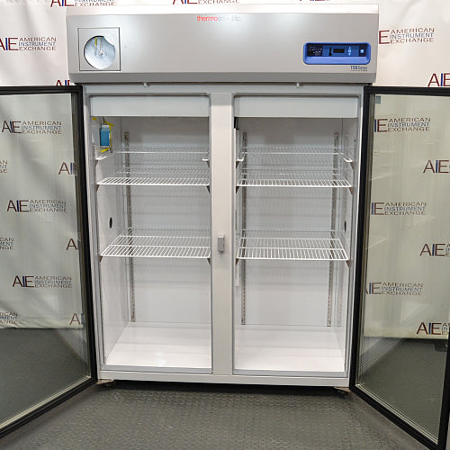 Front view of a Thermo Scientific TSX5005CA high-performance laboratory refrigerator with both glass doors swung fully open, revealing adjustable interior wire shelves and a bright white compartment lining