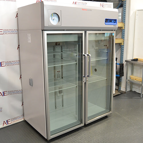 Three-quarter angle product view of a Thermo Scientific TSX5005CA high-performance laboratory refrigerator, highlighting its solid side panel, dual glass doors, vertical handles, and top-mounted digital display unit