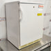 Thermo Scientific undercounter laboratory refrigerator ka left angle view, jisme white exterior body, door handle, key lock, aur bottom ventilation grille stainless steel table par rakhe hue saaf nazar aa rahe hain.   