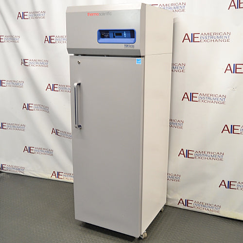 Right angled perspective view of a Thermo TSX1230FA high-performance -30C freezer, featuring its light grey cabinet housing, tall solid locking door with a vertical handle, and top control console with digital display