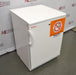 Three-quarter high-angle perspective view of a white Thermo Scientific undercounter flammable material storage refrigerator showing the top, side, and front door with a warning label