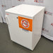 Three-quarter side perspective view of a white Thermo Scientific undercounter flammable material storage unit showing the front door handle and safety warning label
