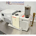 Front product view of a Thermo Scientific VLP120 deep vacuum oil pump, featuring a white motor housing, central control block, vertical exhaust filter canister, and brass inlet fitting on a stainless steel lab bench