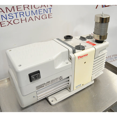 Right three-quarter angle product view of a Thermo Scientific VLP120 deep vacuum oil pump, displaying its white motor assembly, power switch, central pump block, and vertical exhaust filter on a stainless steel bench