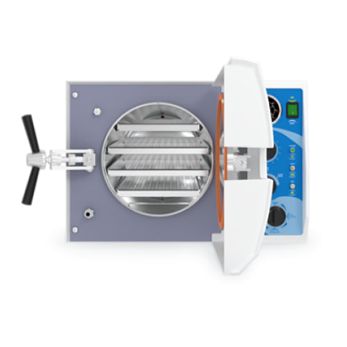 Front angle product view of a Tuttnauer 2540MK 23L Manual KwiKlave autoclave with its front door swung open, showing the orange door gasket, cylindrical stainless steel inner chamber, and loaded internal instrument trays