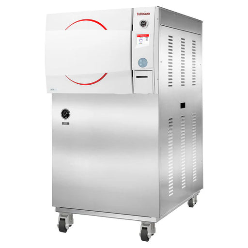 Three-quarter angle view of a stainless steel Tuttnauer 3870HSG-WS floor-standing autoclave unit on casters, featuring a white door with red circular design accents, top control panel with display, and side ventilation slots