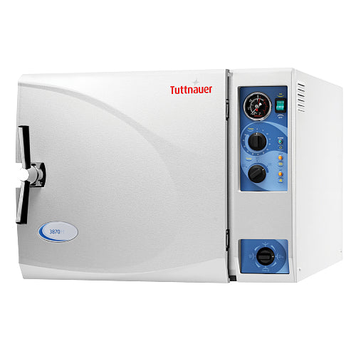 Front angle product view of a Tuttnauer 3870M 85L large-capacity manual autoclave, showcasing its light grey housing, front loading door with a chrome locking handle, and a right-hand control panel featuring mechanical dials and a pressure gauge