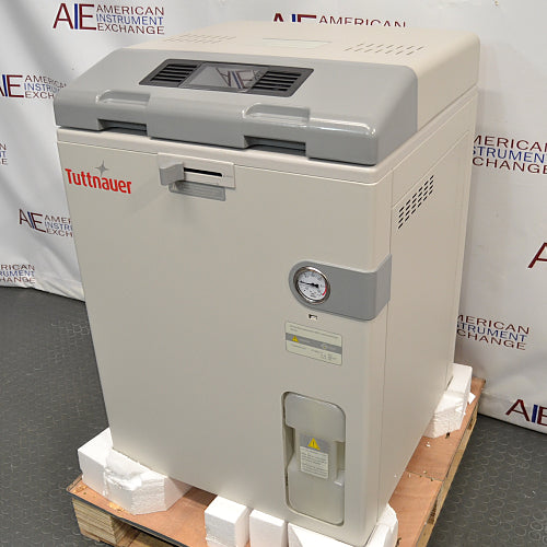Right angle product view of a Tuttnauer LabSci 85LV vertical autoclave on a wooden shipping pallet, showing its beige enclosure, grey control console, integrated pressure gauge, and front lower water container
