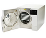 Three-quarter perspective view of a white Tuttnauer T-Top 11S tabletop autoclave with its door swung open, showing the internal sterilization chamber with loaded trays and touchscreen control panel
