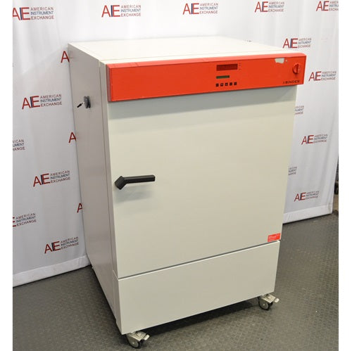 A white, upright Binder KB240 refrigerated incubator with a distinctive orange control panel, positioned in front of an American Instrument Exchange backdrop.