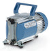 Front three-quarter product view of a Vacuubrand MD 1 diaphragm vacuum pump, featuring its blue and silver finned housing, top blue carrying handle, specification label, and vertical port setup