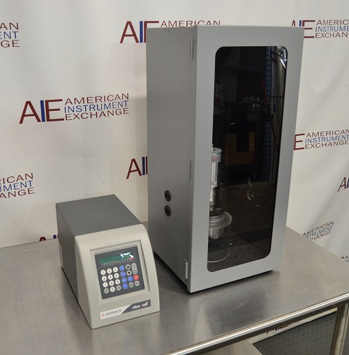 Angled perspective view of Sonics Vibra-Cell VCX 500 ultrasonic processor control unit standing beside a tall sound-abating enclosure housing the converter assembly