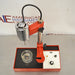 High-angle three-quarter product view of a Virtis Model 23 micro homogenizer, displaying its red and chrome motor drive, vertical support stand, base platform with control panel, and glass container on a stainless steel bench