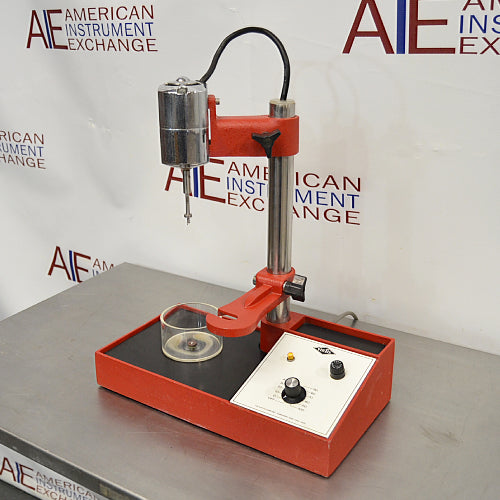 Left three-quarter angle product view of a Virtis Model 23 micro homogenizer, featuring its red and chrome motor drive assembly, vertical support column, base platform with control console, and glass mixing container on a stainless steel bench