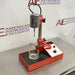 Right three-quarter angle product view of a Virtis Model 23 micro homogenizer, showing its red and chrome motor drive on a vertical stand, integrated control panel, base platform, and glass vessel on a stainless steel lab bench
