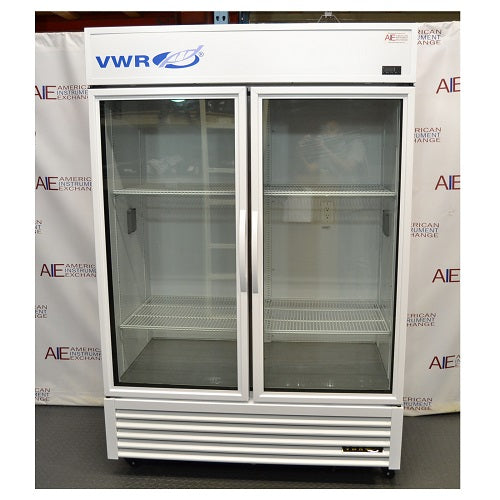 Front eye-level view of a VWR double door chromatography refrigerator with glass doors, white exterior housing, blue branding logo, internal wire shelving, and a bottom louvered grill panel