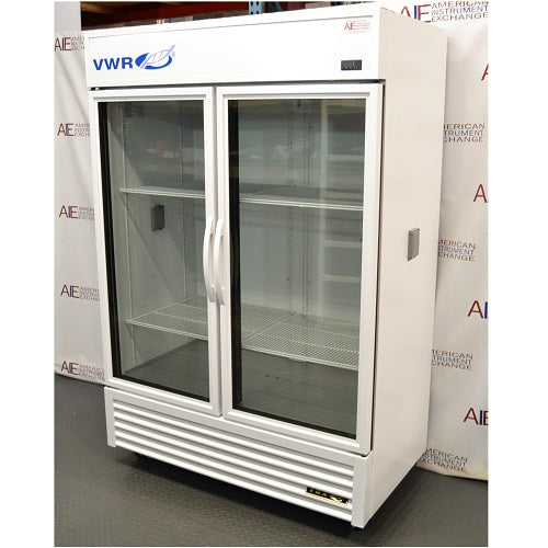 Left angled perspective view of a VWR double door chromatography refrigerator showcasing its white exterior casing, glass doors, vertical handles, internal wire shelves, and lower vented grill panel