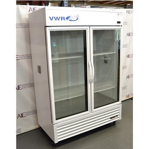 Right angled perspective view of a VWR double door chromatography refrigerator featuring its white housing, glass doors with vertical handles, internal wire shelving, side panel ports, and lower grill panel