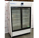 Left angled perspective view of a VWR HCCP-47-TS Performance Series chromatography refrigerator, showcasing its white exterior casing, dual sliding glass doors, internal wire shelving, and bottom louvered grill panel