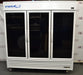 Straight-on front view of a VWR triple glass door laboratory refrigerator on caster wheels, featuring a white cabinet body, three tinted glass doors with vertical handles, top blue branding, and a louvered bottom grille
