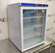 Angled perspective view of a VWR undercounter glass door laboratory refrigerator resting on a stainless steel surface showcasing its door handle, glass front, and top control console