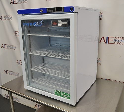 Right angled perspective view of a VWR undercounter glass door laboratory refrigerator resting on a stainless steel surface showcasing its right side panel, glass front, and top control interface