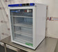 Right angled perspective view of a VWR undercounter glass door laboratory refrigerator resting on a stainless steel surface showcasing its right side panel, glass front, and top control interface