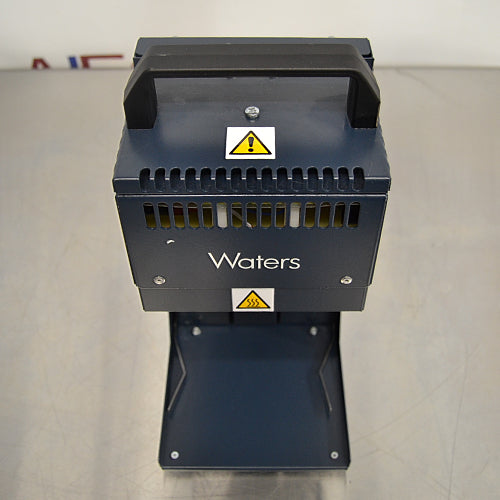 Overhead angle product view of a Waters Combi Thermo Sealer plate sealing machine, showcasing the top handle, safety warning labels, ventilation grille, and base platform on a lab bench