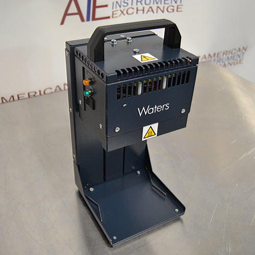 Three-quarter angle product view of a Waters Combi Thermo Sealer plate sealing machine, showcasing the top carrying handle, indicator lights on the side panel, hot surface warning labels, and base platform on a lab bench