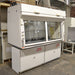 A white Fisher Hamilton 8' Chemical Fume Hood with flammable storage base cabinets, featuring a split vertical-rising sash, a work surface, and various fixtures such as monkey bars and external outlets.